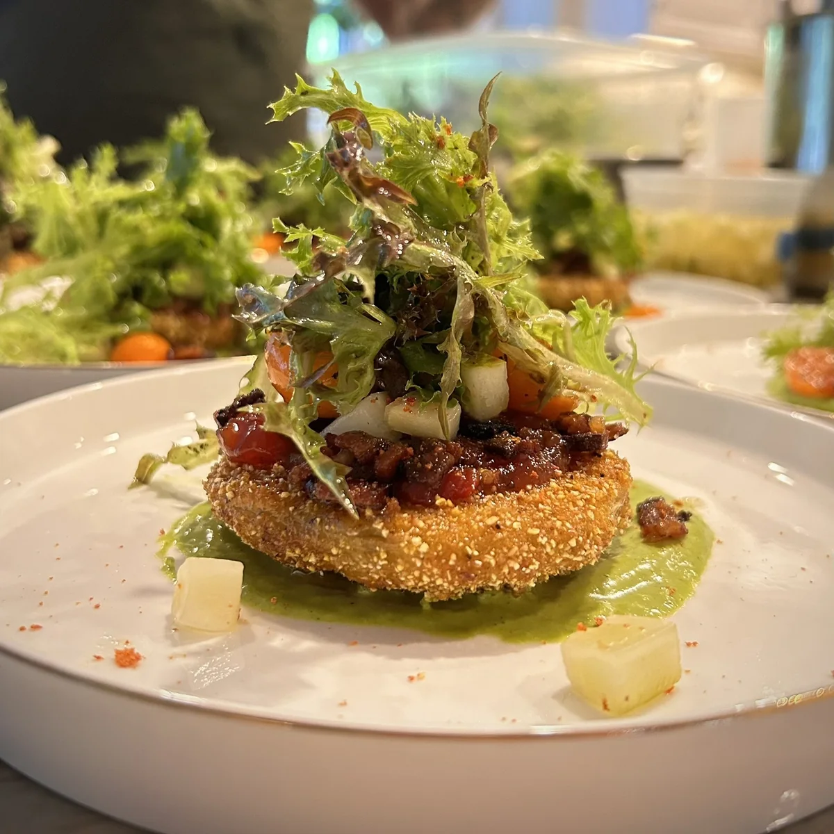 Crispy fried green tomato appetizer with frisée salad